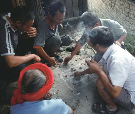 陰雨天,三五瑤民聚在一起玩瑤族傳統(tǒng)“趕豬棋”。